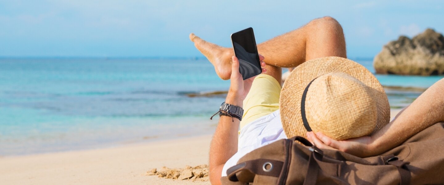 Man on beach using phone