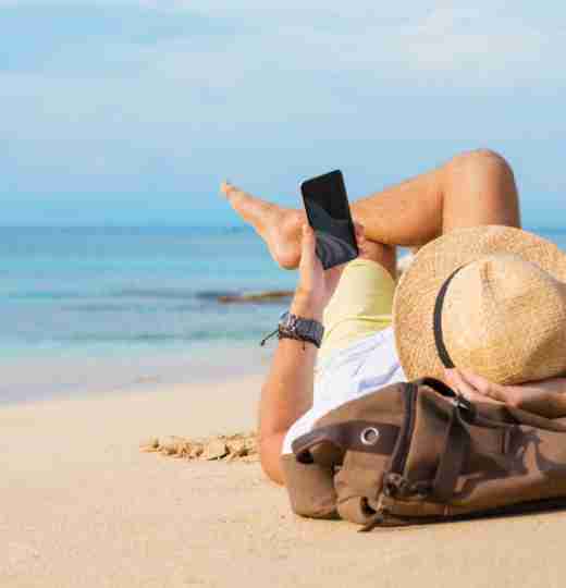 Man on beach using phone