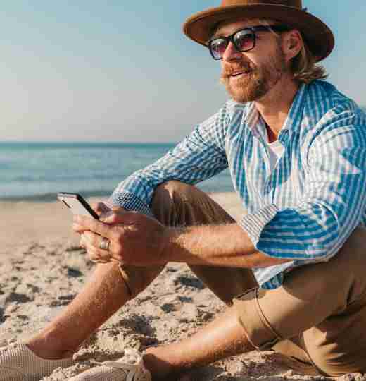 Man with phone on beach
