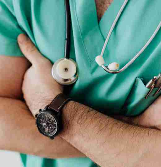 Person wearing green healthcare scrubs with stethoscope